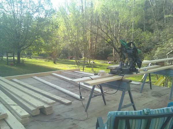 Miter saw and framing lumber on a deck under construction in Midland